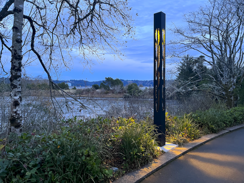 Lit Column By The Water At Dusk